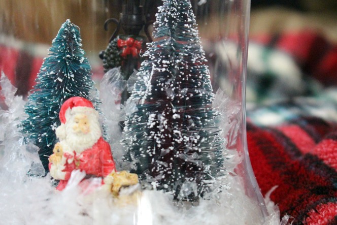 Glass vase filled with artificial snow and ornaments and